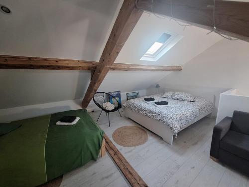 Cette chambre mansardée comprend un lit et un canapé. dans l'établissement Appartement cosy duplex Vichy, à Vichy