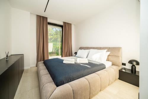 a bedroom with a bed and a large window at The Villa O in Sarajevo