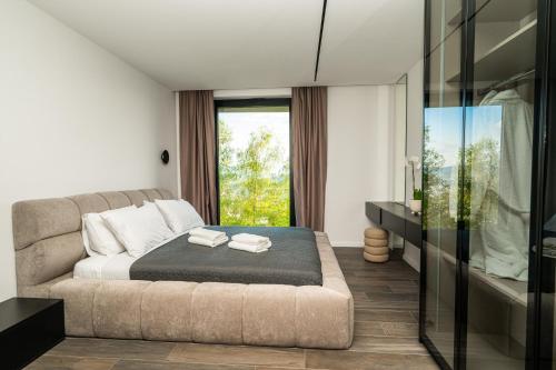 a bedroom with a bed and a large window at The Villa O in Sarajevo