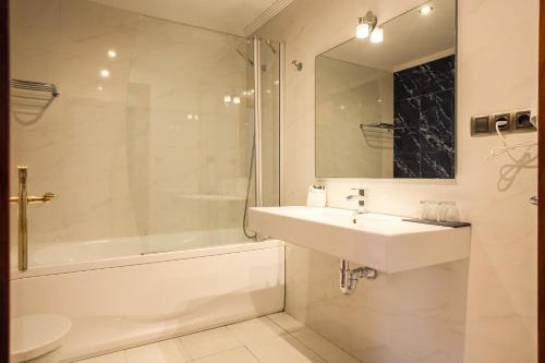 a white bathroom with a sink and a shower at Indiana Boutique Hotel in Llanes