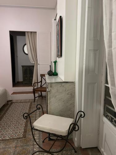 a white chair in a room with a window at L Oranger in Rivesaltes
