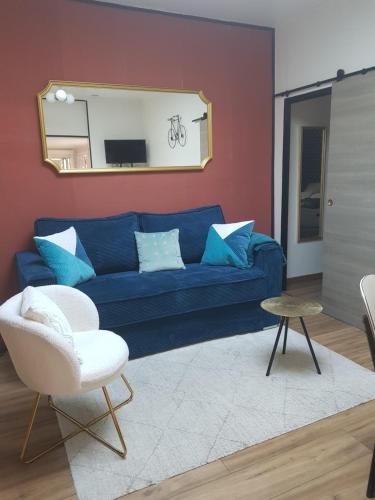 un salon avec un canapé bleu et un miroir dans l'établissement Maison cosy citadine, à Tours
