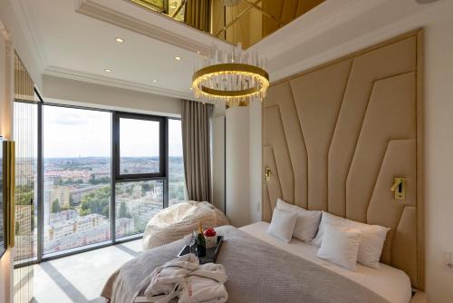a bedroom with a large bed with a large window at HANZA TOWER GOLD 19th Floor in Szczecin