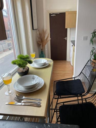 a table and chairs with plates and glasses on it at Bude A2 - CosySaver in Belle Isle