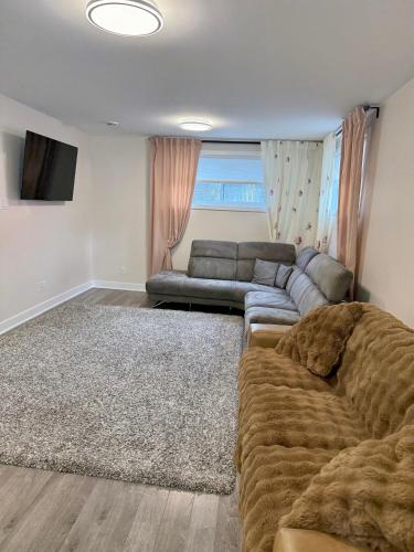 a living room with a couch and a television at Confort & Harmonie in Longueuil