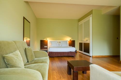 a hotel room with a bed and a couch and a table at Indiana Boutique Hotel in Llanes
