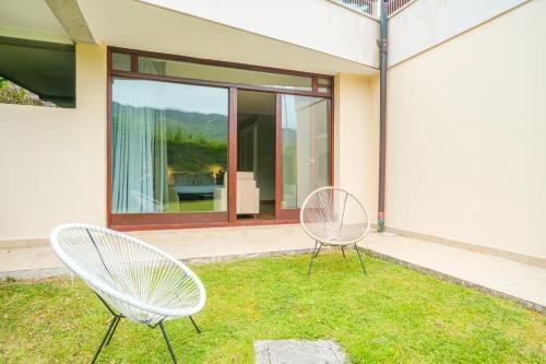 two chairs sitting in the grass in front of a house at Indiana Boutique Hotel in Llanes