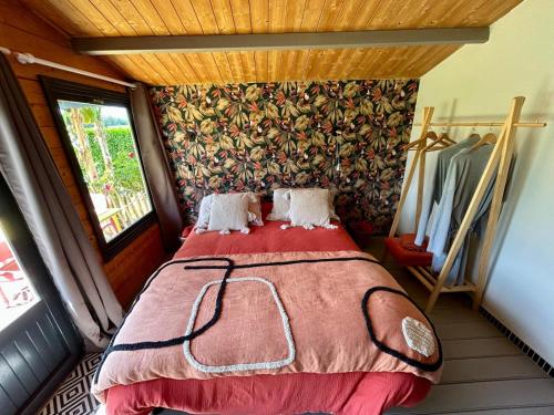 une chambre avec un lit dans une pièce avec une fenêtre dans l'établissement La Cabane du Verger, à Montignac