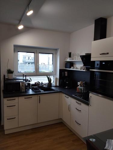 a kitchen with white cabinets and black counter tops at Ferienwohnung Toni in Memmingen