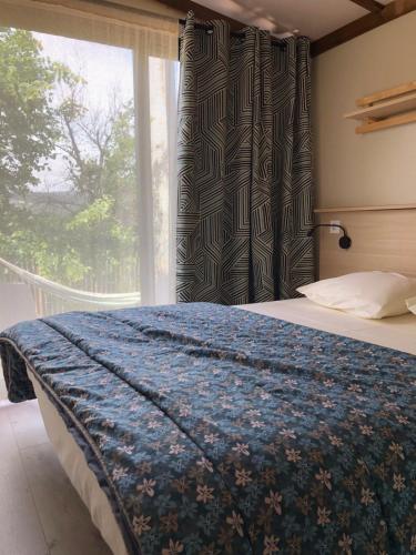 a bedroom with a bed and a window with a view at Manoir de Champvert in Les Vans