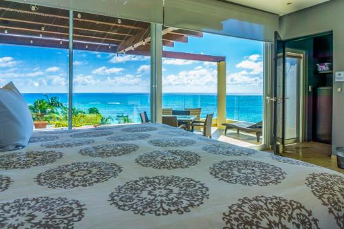 プラヤ・デル・カルメンにあるThe Elements Oceanfront & Beachside Condo Hotelの海の見えるベッドのある寝室