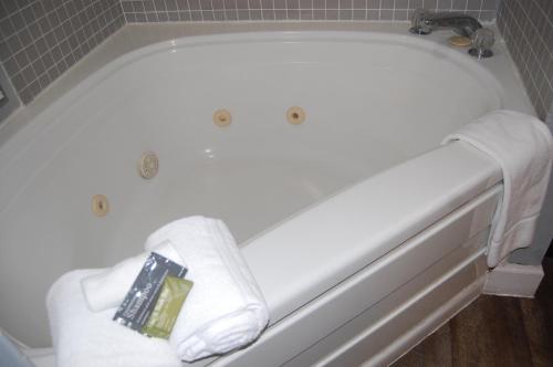 a white bath tub with towels and a book on it at Vacation Lodge in Pigeon Forge