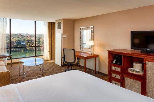 a hotel room with a bed and a desk and a television at Holiday Inn Austin -Town Lake by IHG in Austin