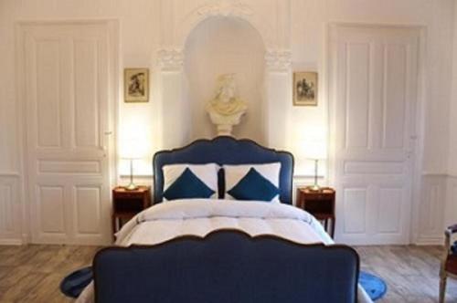 a bedroom with a blue bed with blue pillows at Hôtel Le 43 in Luxeuil-les-Bains