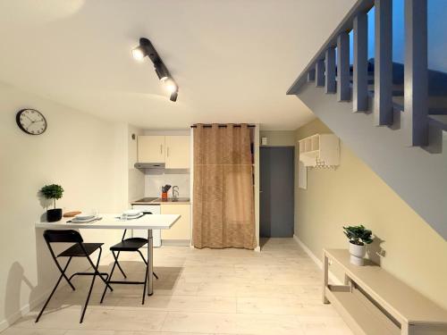 une cuisine avec une table et des chaises ainsi qu'un escalier dans l'établissement Appartement, Parking, WIFI,, à Le Monastère