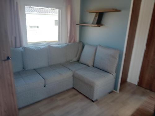 a living room with a couch and a window at chalet bella in Gasselte