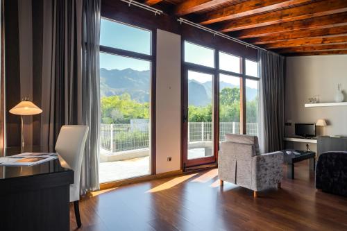 a living room with a large window and a chair at Indiana Boutique Hotel in Llanes