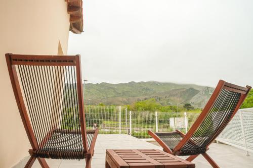 two chairs on a balcony with a view of a mountain at Indiana Boutique Hotel in Llanes