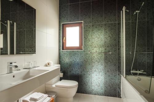 a bathroom with a toilet and a sink and a shower at Indiana Boutique Hotel in Llanes