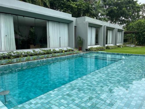 a swimming pool in front of a house at Residência Executiva de Alto Padrão - COP30 in Benevides