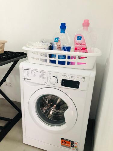 a washing machine with bottles and containers on top of it at AMU- Apartamentos Mistérios da Urzelina in Urzelina