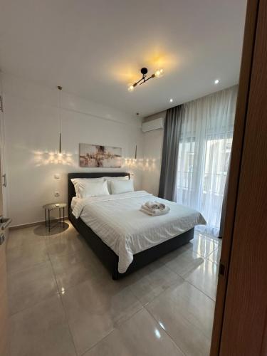 a bedroom with a white bed and a window at Agora by Rapsani beach ! in Kavála