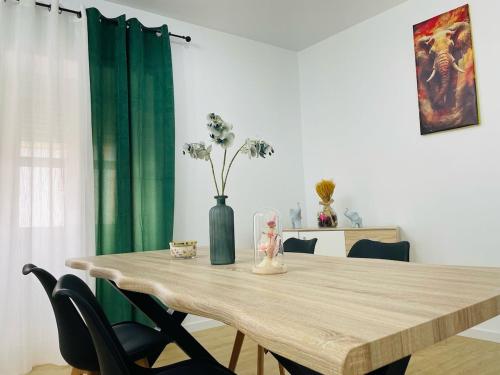 a dining room table with a vase with flowers on it at Casa da Edda in Elvas