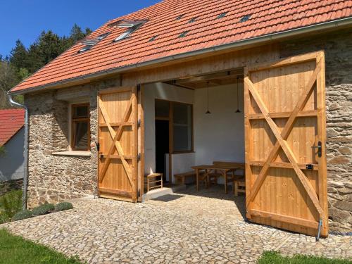an open garage with wooden doors on a building at Stodola 63 in Pacov