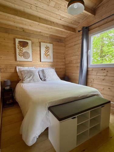 une chambre avec un lit dans une cabane en bois dans l'établissement Ô Village, à Giromagny