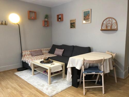 un salon avec un canapé et une table dans l'établissement Le Cozy near center train station & SciencesPo, à Dijon