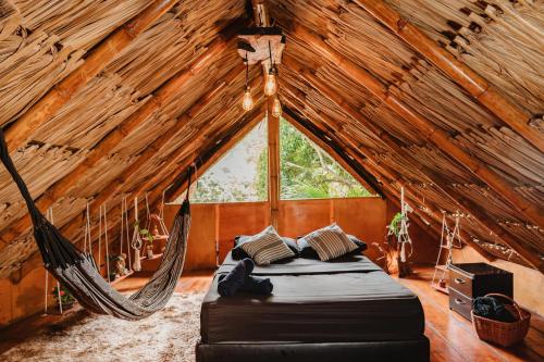 a hammock in a room with a window at Kasakolà in Palomino