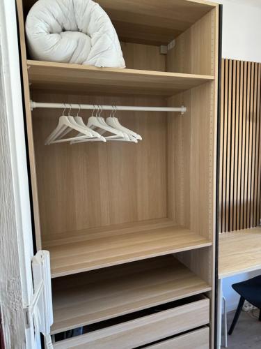 un placard avec des étagères en bois et des chaussures blanches dans l'établissement Very charming studio, Vieux Port - old port, à Marseille