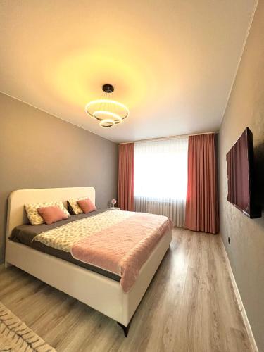 a bedroom with a bed and a window at Kakdoma Apartments in Kostanay