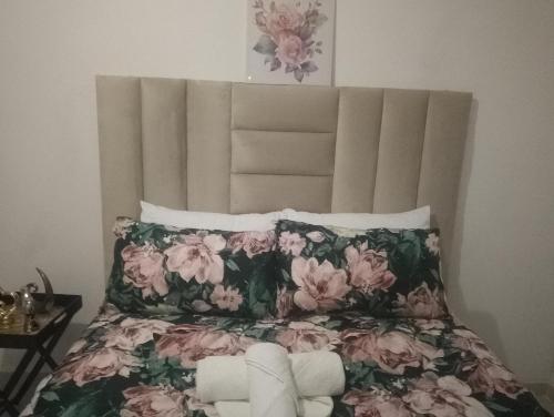 a bedroom with a bed with pink flowers at Khetshane Consortium private park and restaurants in Ntswanahatshe