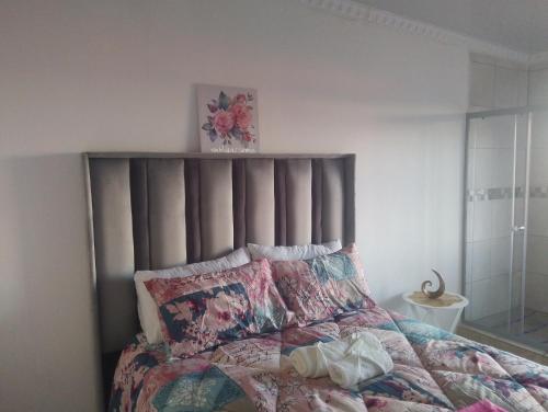 a bedroom with a bed with a gray headboard at Khetshane Consortium private park and restaurants in Ntswanahatshe