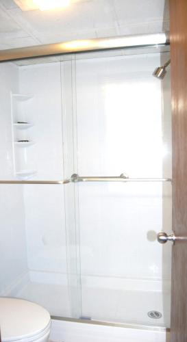 a glass shower door in a bathroom with a toilet at Vacation Lodge in Pigeon Forge