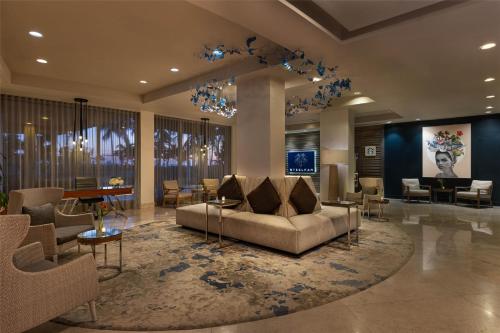 a lobby with a couch and a table and chairs at Sonesta Fort Lauderdale Beach in Fort Lauderdale
