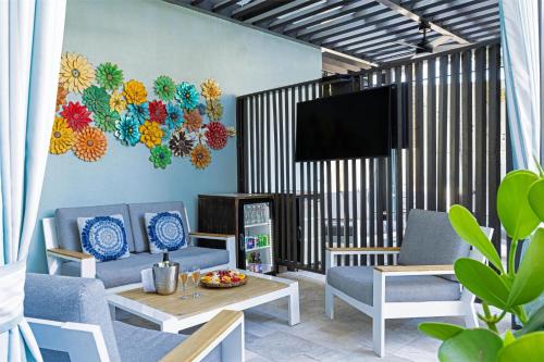 a living room with two chairs and a tv at Sonesta Fort Lauderdale Beach in Fort Lauderdale