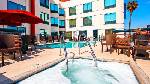 a hot tub at a hotel with chairs and a building at Best Western Plus Suites Hotel - Los Angeles LAX Airport in Inglewood