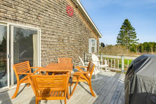 a wooden table and chairs on a deck at Bay Views Peaceful Acadia National Park Getaway! in Steuben