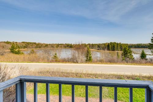 a wooden bench sitting on a fence next to a road at Bay Views Peaceful Acadia National Park Getaway! in Steuben