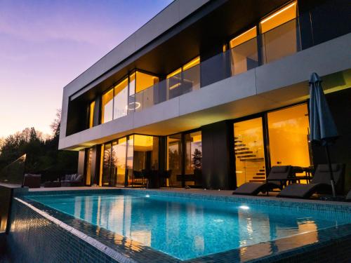 a house with a swimming pool in front of it at The Villa O in Sarajevo