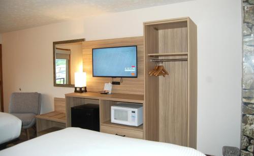 a hotel room with a bed and a tv at Vacation Lodge in Pigeon Forge