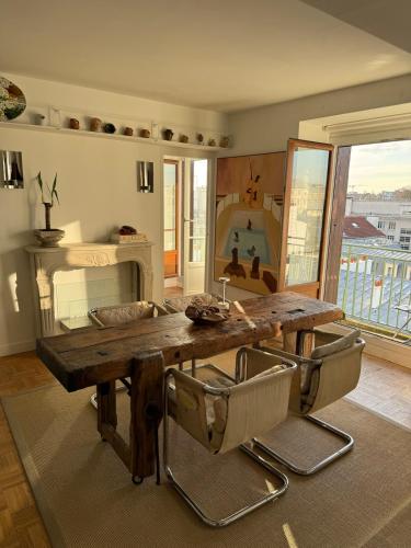 un salon avec une table et des chaises en bois dans l'établissement Appartement canal saint Martin, à Paris