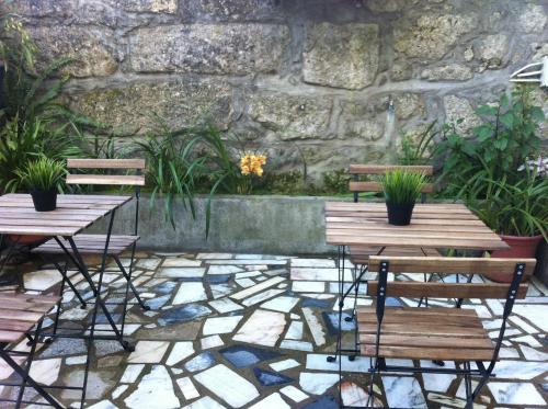 a patio area with benches, tables, and plants at Hotel Mira D'Aire in Porto