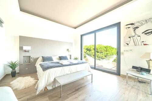 une chambre avec un lit et une grande fenêtre dans l'établissement Cozy Villa Yrene w Pool, à Vallauris