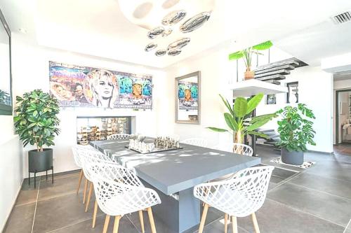 une salle à manger avec une table et des chaises blanches dans l'établissement Cozy Villa Yrene w Pool, à Vallauris