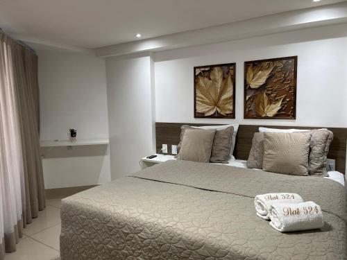 a bedroom with a large bed with two pillows on it at Gold Flat Cabo Branco in João Pessoa