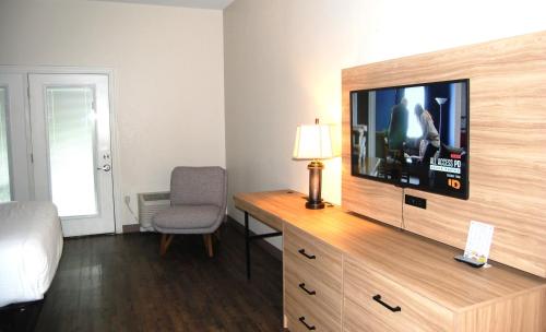 a hotel room with a television on a wooden dresser at Vacation Lodge in Pigeon Forge