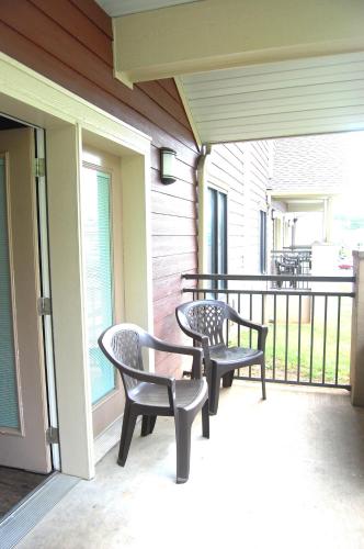 a porch with two chairs and a railing at Vacation Lodge in Pigeon Forge